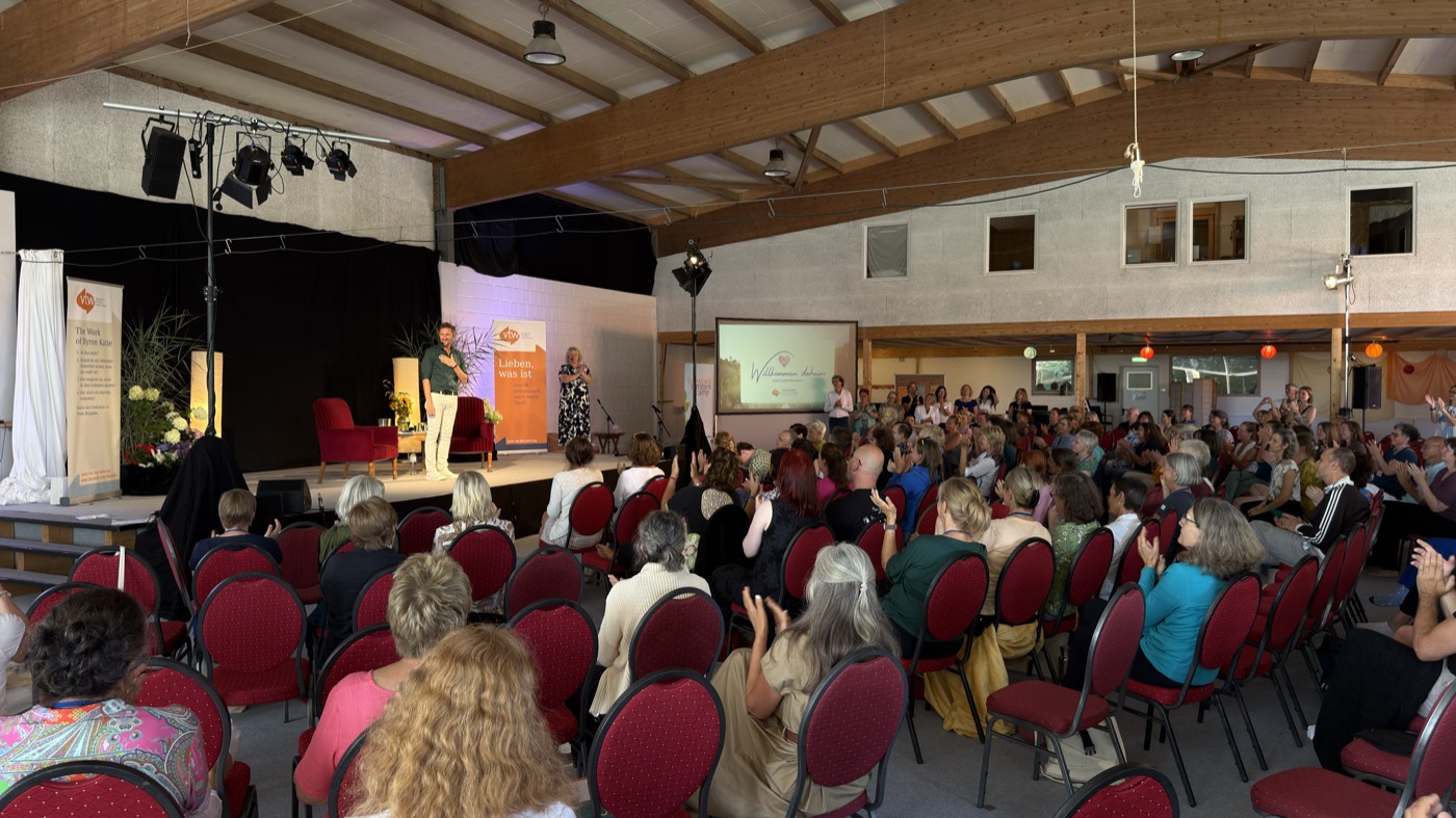 Chris auf der Bühne vor den Teilnehmenden im Saal des Summer Camps