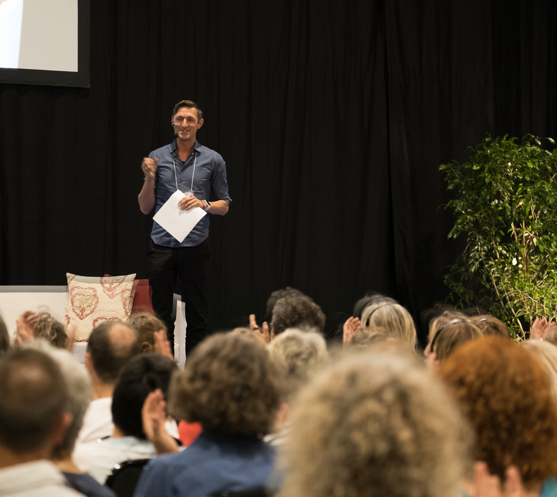 Chris Spieler auf der Bühne vor einem applaudierenden Publikum in Engelberg