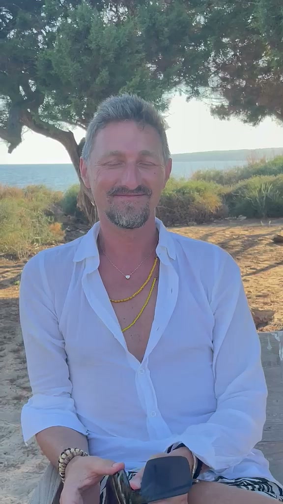 Chris hält am Meer mit geschlossenen Augen inne und lauscht nach innen