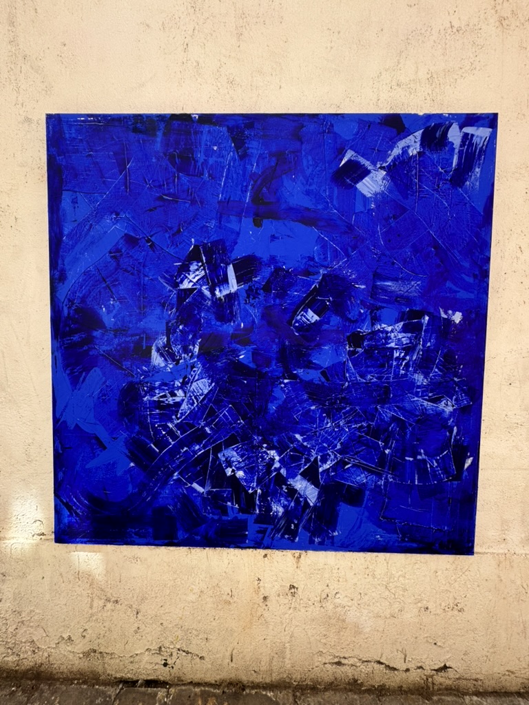 Abstraktes Bild in kräftigen Blautönen an einer hellen Wand